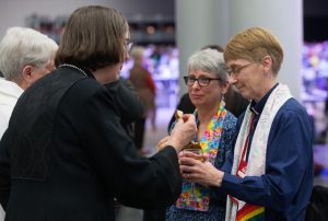 Bishops Sharon Radar and Elaine Stanovsky (left foreground) receive elements at what was declared as one of the "Queer Communion Stations" from Sue Laurie (right) and Julie Bruno during opening worship at the 2016 United Methodist General Conference in Portland, Oregon. Photo by Mike Bose, UMNS
